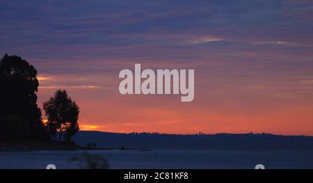 coucher de soleil spectaculaire et coloré avec ciel nuageux . Le soir, calme sur le lac de llanquihue. Une lumière intense. Banque D'Images