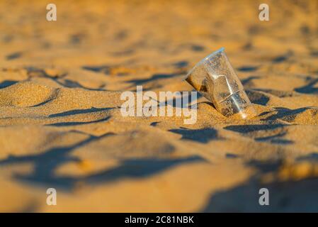 Gobelet en plastique sur la plage de sable doré de l'océan, playa de las Teresitas, Tenerife. Concept de conservation de l'environnement. Mers et océans polluti Banque D'Images