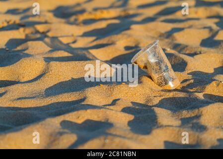 Gobelet en plastique sur la plage de sable doré de l'océan, playa de las Teresitas, Tenerife. Concept de conservation de l'environnement. Mers et océans polluti Banque D'Images