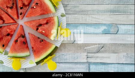 Plat de tranches de pastèque triangulaires sur bâtonnets. Glaces aux fruits frais rafraîchissantes Banque D'Images