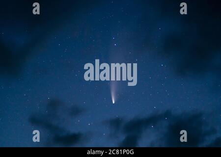 Comet C/2020 F3 (NEOWISE) vu le 20 juillet 2020 du pays de Galles, Royaume-Uni, au crépuscule astronomique, entouré de nuages. Hémisphère Nord. Banque D'Images