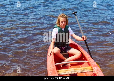 Joyeux garçon actif en vacances d'été. Adolescent ayant le plaisir de profiter de l'aventure expérience de kayak sur le lac lors d'une journée ensoleillée en été Banque D'Images