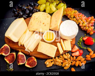 Assiette de fromage servi avec des raisins, confiture, figues, les craquelins et les écrous Banque D'Images