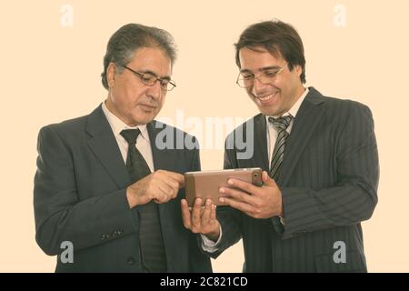 Portrait of happy young et senior businessman smiling persique lors de l'utilisation de digital tablet Banque D'Images