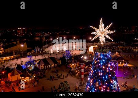 Photo aérienne du magnifique arbre de Noël illuminé au crépuscule avec écran led Banque D'Images