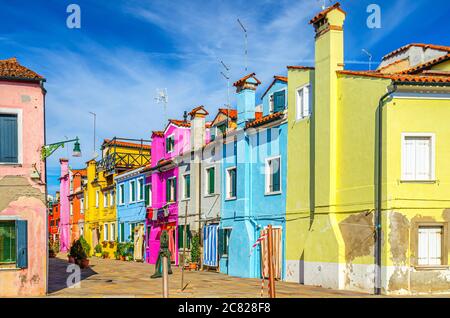 Maisons colorées de l'île de Burano. Bâtiments multicolores dans une rue étroite, ciel bleu en plein soleil, province de Venise, région de Vénétie, Italie du Nord. Carte postale Burano Banque D'Images