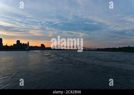 Vue sur la ville un pont en acier traversant une rivière à l'époque entre le coucher du soleil et le crépuscule. Le pont Jacques Cartier est situé de l'autre côté de la rivière Saint-Laurent. Gauche est Cl Banque D'Images