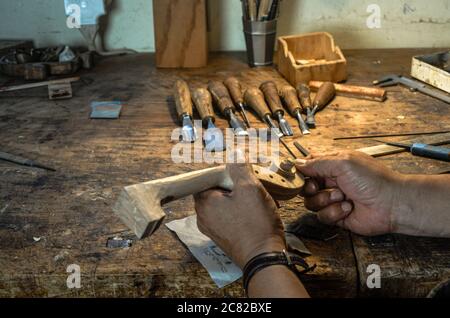 Luthier Carlos Roberts, le violoniste dans son atelier de Cremona Italie sculptant et sculptant un rouleau de violon Banque D'Images