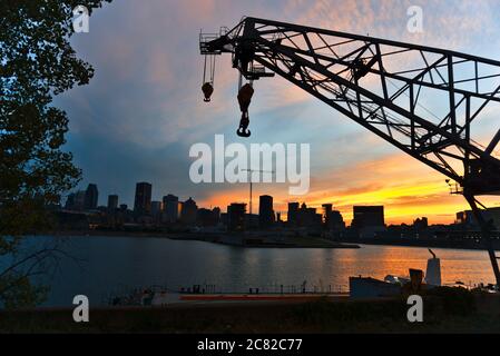 Horizon du centre-ville de Montréal à l'époque entre le coucher du soleil et le crépuscule. Réflexions de rayons du soleil sur la rivière Saint-Laurent. Le premier plan est un chargeur sur un bateau. M Banque D'Images