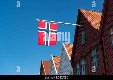 Le drapeau norvégien vole depuis un toit d'un bâtiment à Bergen, en Norvège Banque D'Images