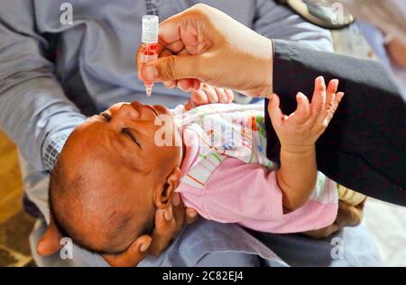 Un travailleur de la santé administre des gouttes de vaccin contre la polio à un enfant lors de la campagne de vaccination contre la polio qui a lieu dans la région de Nazimabad à Karachi le lundi 20 juillet 2020. Une petite campagne de vaccination contre la polio sera lancée dans la métropole à partir d'aujourd'hui, à Baldia, Orangi Town, North Nazimabad, Liaquatabad et dans la région OÙ environ 260,000 enfants âgés de moins de cinq ans seront administrés le vaccin oral contre la polio. Banque D'Images