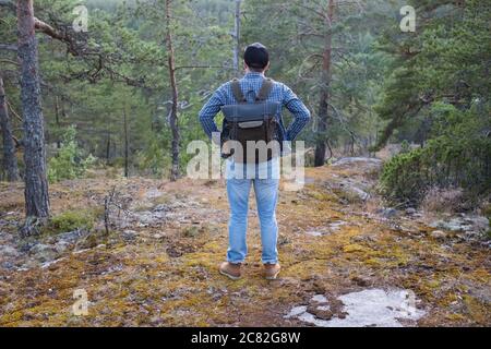 Jeune homme caucasien randonnée en plein air dans les bois. Vue arrière Banque D'Images