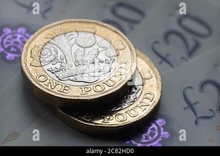 De nouvelles pièces d'une livre sont placées sur les nouveaux billets de livre sterling. Gros plan avec mise au point sélective. L'accent principal est mis sur les pièces. Banque D'Images