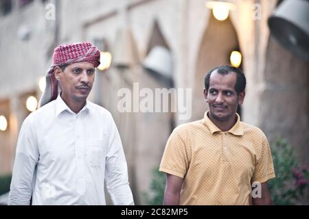 Inmigrant asiatique et homme saoudien à Souq Waqif, Doha, Qatar Banque D'Images