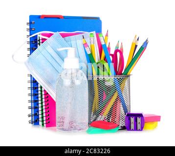 Groupe de fournitures scolaires et articles de prévention COVID 19 isolés sur fond blanc. Retour à l'école pendant la pandémie concept. Banque D'Images