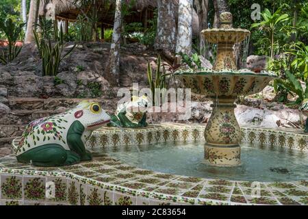 Les grenouilles en céramique peintes font couler de l'eau dans une fontaine colorée de carreaux mexicains sur le terrain de l'hôtel Mayaland à Chichen Itza, Yucatan, Mexique. Banque D'Images