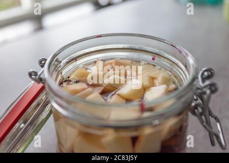 Gros plan d'une banque de verre avec fruits coupés une table grise Banque D'Images