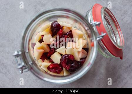 Gros plan d'une banque de verre avec fruits coupés une table grise Banque D'Images