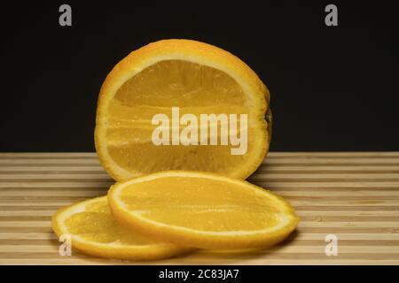 orange frais sur plateau en bois avec fond noir Banque D'Images