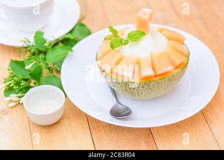 Melon Bingsu avec Lait condensé Sucré sur table en bois Banque D'Images