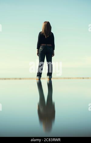 Vue arrière de la femme avec réflexion sur l'eau Banque D'Images