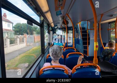 Les personnes portant un masque facial assis sur un trajet en bus s'assoient en dehors des règles de distance sociale Banque D'Images