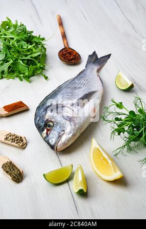 Dorada poisson sur la table avec des épices et des herbes Banque D'Images