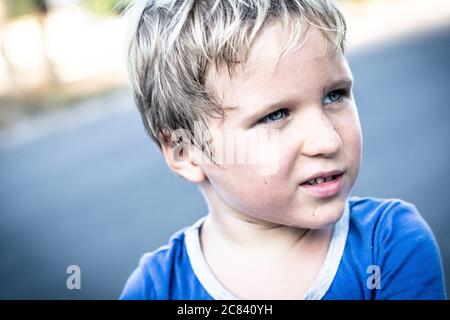 Portrait d'un drôle heureux espiègle gai mignon blond bleu eyed garçon faisant des taches de freckles visage sale tout en jouant, rire. Garderie, bonne enfance Banque D'Images