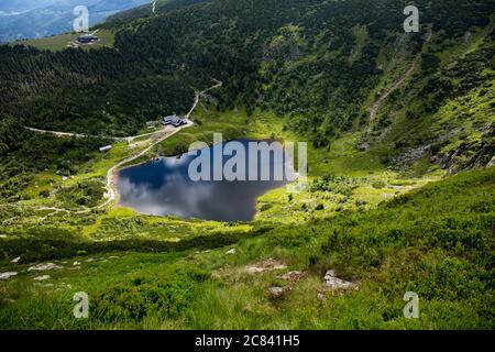 Vue sur un lac naturel d'origine glaciaire appelé Maly Staw (le petit étang) et le refuge de montagne de Samotnia dans le parc national de Karkonosze. Karkonosze (les Monts Krknose ou géants) sont des chaînes de montagnes situées dans le nord de la République tchèque et le sud-ouest de la Pologne. Les Karkonosze sont un exemple unique du paysage alpin de la région et sont une réserve naturelle depuis 1933. Banque D'Images