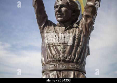 RIO DE JANEIRO, BRÉSIL - 12 juillet 2020 : gros plan de la statue de bronze d'Ayrton Senna tenant un drapeau brésilien haut avec sa suite de course pleine de compagnie Banque D'Images