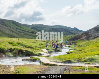 Islande, Hveragerdi, 5 août 2019 : bain géothermique naturel surpeuplé dans un ruisseau de rivière chaude dans la vallée de Reykjavadalur avec groupe de baignade et de détente Banque D'Images