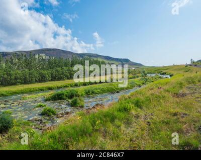 Paysage idyllique de Hveragerdi près de la vallée de Reykjavadalur avec rivière Hot Springs, prairie verte luxuriante et collines. Islande du Sud. Matin ensoleillé en été Banque D'Images