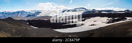 Vue panoramique sur le paysage volcanique rouge et noir de l'Islande sur le sentier de randonnée de Fimmvorduhal avec champ de lave du volcan glacier, neige et colline de magni et mudi Banque D'Images