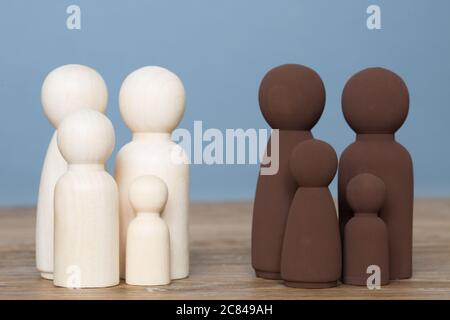 Une famille noire et une famille blanche se tenant à l'écart dans un concept de minorité ethnique divisée Banque D'Images