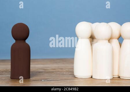 Un concept de ségrégation raciale d'une personne noire étant séparée d'un groupe de personnes blanches en raison de sa couleur Banque D'Images