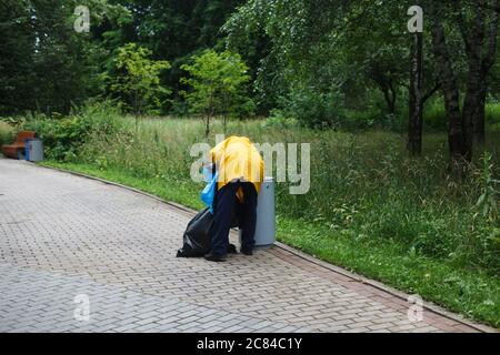 Homme triant les ordures dans le parc public. Collecte des déchets Banque D'Images