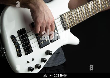 le joueur de guitare basse joue de la guitare électrique de basse à la finition blanche polie, de la musique live. Banque D'Images