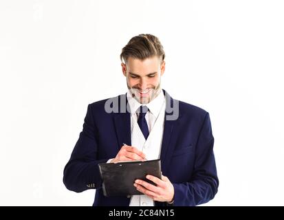 Concept de transaction réussie. Homme au visage heureux écrit sur planchette sur fond blanc. L'homme d'affaires signe le document. Homme d'affaires avec une apparence jeune et une tenue classique tient le bloc et le stylo Banque D'Images