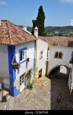 Obidos, Portugal - 1er juin 2017 : charmante rue médiévale de la vieille ville d'Obidos au Portugal. Monument national de Vila de Obidos. Casa do Arco da Cadeia Banque D'Images