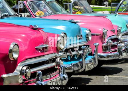 Cuba, la Havane : vieilles voitures américaines étincelantes de rose et de bleu Banque D'Images