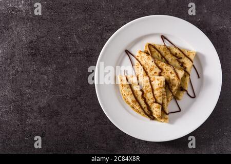 Crêpes sucrées au chocolat sur fond noir. Banque D'Images