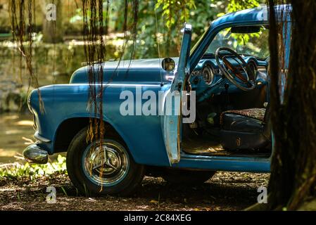 Cuba : voitures américaines classiques à la campagne. Blue Chevrolet avec porte ouverte apparemment abandonné au milieu des traverses Banque D'Images