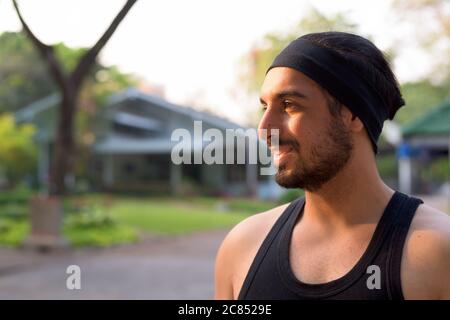 Vue en gros plan du jeune homme indien barbu souriant au parc Banque D'Images