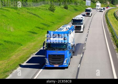 Quatre camions, camions-citernes Volvo FH et camion-plateforme Scania sur l'autoroute, un beau jour d'été. Salo, Finlande. 12 juin 2020. Banque D'Images