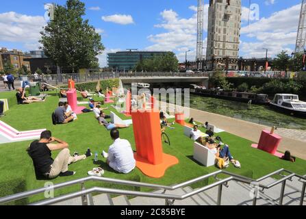 Tandis que le verrouillage Covid facilite l'herbe artificielle est remis sur les marches de Granary Square, avec des séparateurs pop à l'envelly funky pour aider à distancer les sociaux, à Kings Cross, au nord de Londres, Royaume-Uni Banque D'Images