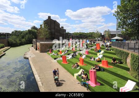 Tandis que le verrouillage Covid facilite l'herbe artificielle est remis sur les marches de Granary Square, avec des séparateurs pop à l'envelly funky pour aider à distancer les sociaux, à Kings Cross, au nord de Londres, Royaume-Uni Banque D'Images