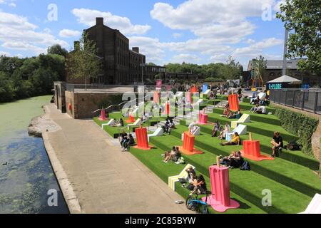 Tandis que le verrouillage Covid facilite l'herbe artificielle est remis sur les marches de Granary Square, avec des séparateurs pop à l'envelly funky pour aider à distancer les sociaux, à Kings Cross, au nord de Londres, Royaume-Uni Banque D'Images