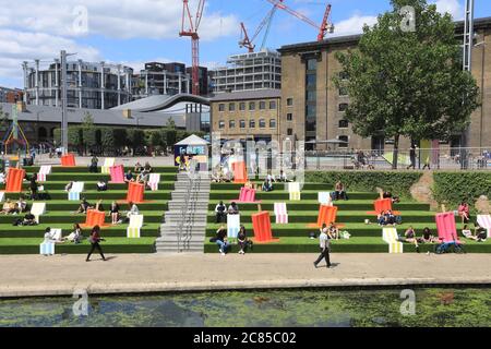 Tandis que le verrouillage Covid facilite l'herbe artificielle est remis sur les marches de Granary Square, avec des séparateurs pop à l'envelly funky pour aider à distancer les sociaux, à Kings Cross, au nord de Londres, Royaume-Uni Banque D'Images