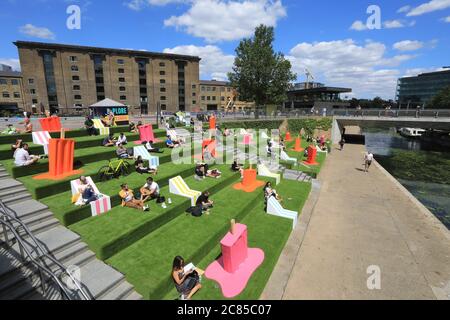 Tandis que le verrouillage Covid facilite l'herbe artificielle est remis sur les marches de Granary Square, avec des séparateurs pop à l'envelly funky pour aider à distancer les sociaux, à Kings Cross, au nord de Londres, Royaume-Uni Banque D'Images