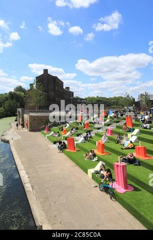 Tandis que le verrouillage Covid facilite l'herbe artificielle est remis sur les marches de Granary Square, avec des séparateurs pop à l'envelly funky pour aider à distancer les sociaux, à Kings Cross, au nord de Londres, Royaume-Uni Banque D'Images